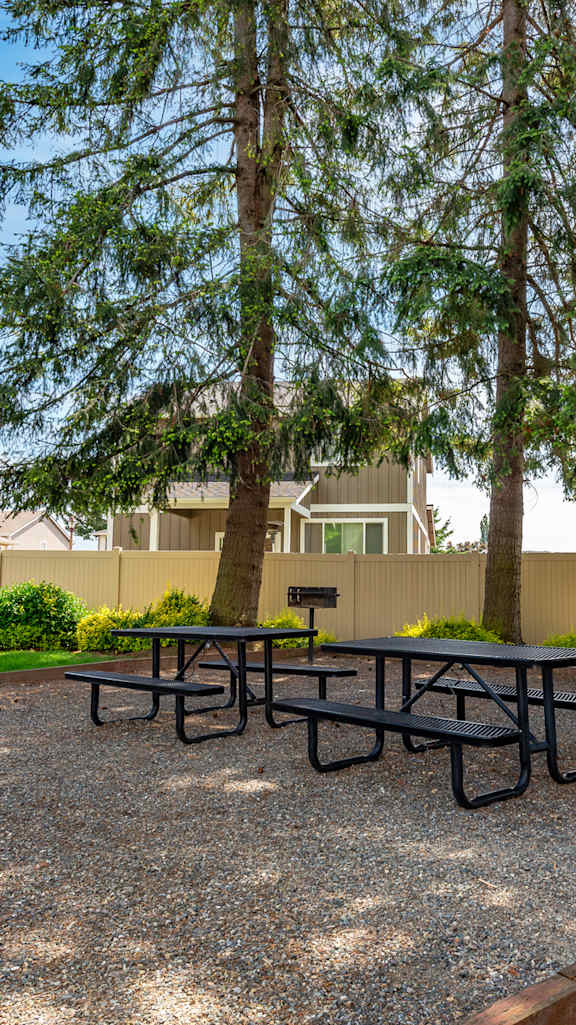 a dining area with a table and chairs and a kitchen in the background