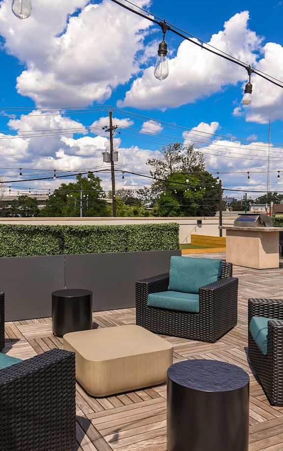 A patio with wicker furniture and a blue sky with clouds.