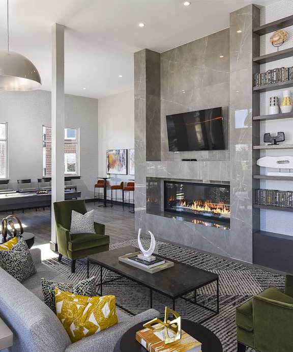 A modern living room with a grey sofa, a fireplace, and a TV on the wall.