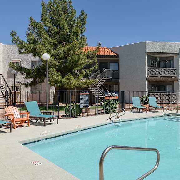 A pool area with chairs and a fountain at Cohea Archibalds.