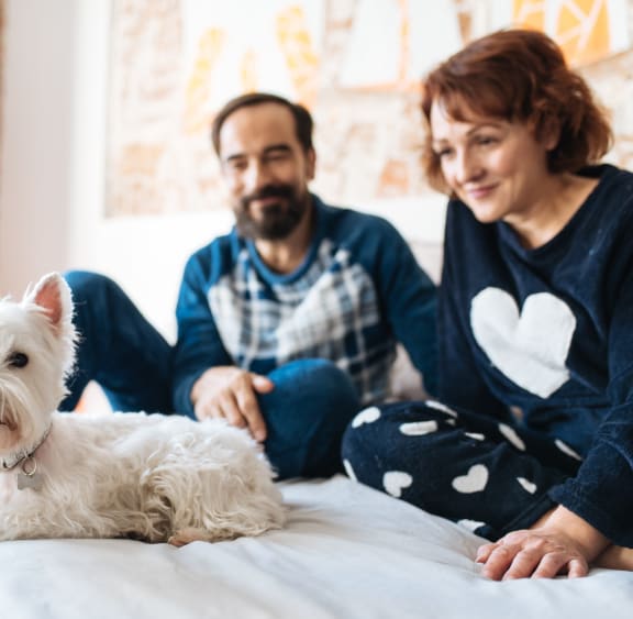 Multnomah Station Couple Laying on Bed With Dog