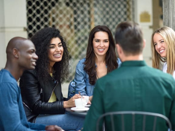 a group of people sitting around a table talking