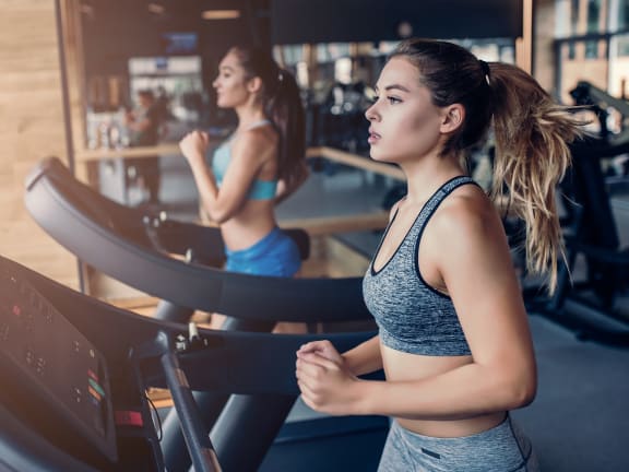 a woman running on a treadmill in a gym