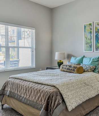 a bedroom with a bed and two lamps and a window