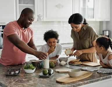 a family gathered around a kitchen counter preparing food