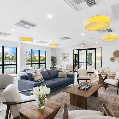a living room with couches chairs and tables and a pool