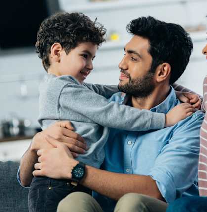 a man and woman sitting on a couch with a child