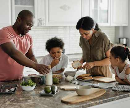 a family gathered around a kitchen counter preparing food