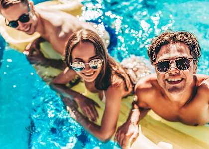 a group of people in a pool wearing sunglasses