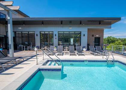 the pool and patio area of a building with a swimming pool at Soll, Des Moines, IA