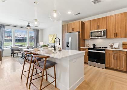 A kitchen with wooden cabinets and a white island.