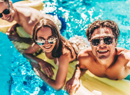 a group of people in a pool wearing sunglasses