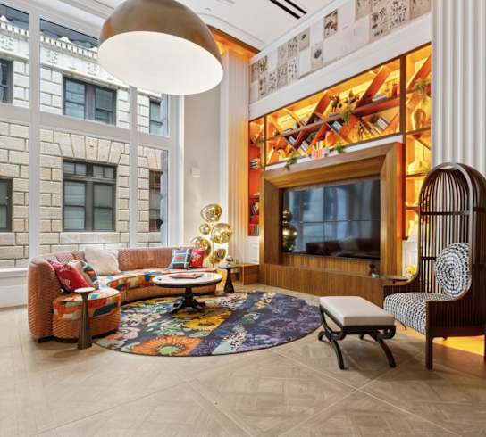 A living room with a couch, chair, and rug.