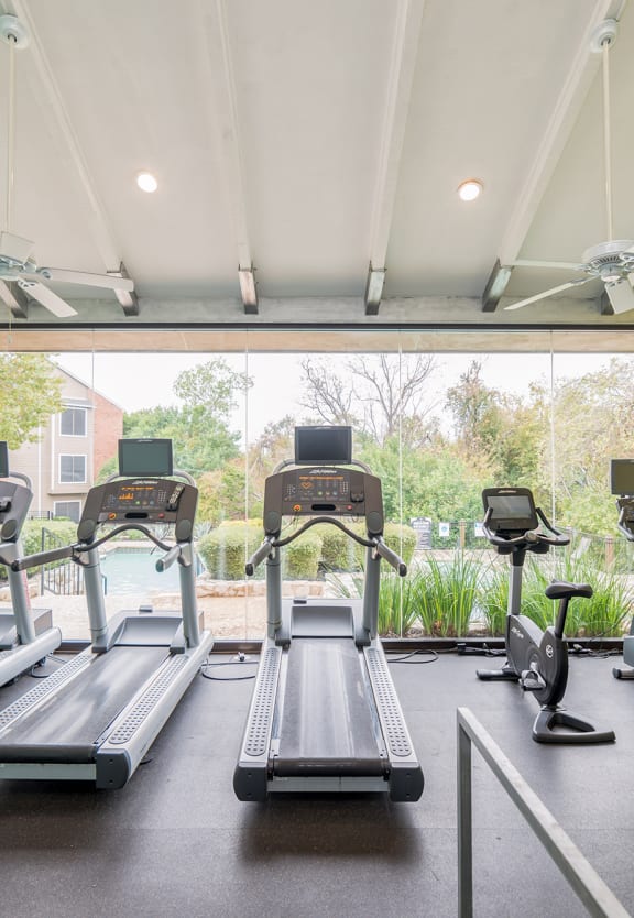 a gym with cardio equipment and window views at High Oaks, Texas, 78759