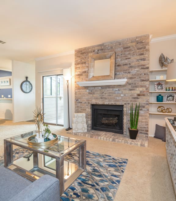 a living room with a brick fireplace and a glass coffee table at High Oaks, Texas, 78759