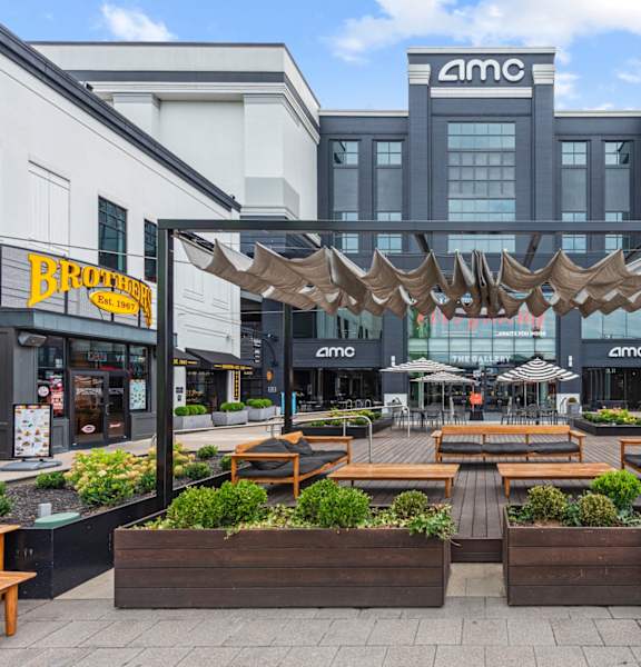 a courtyard with benches and tables in front of a building at Monmouth Row Apartments, Newport, KY, 41071
