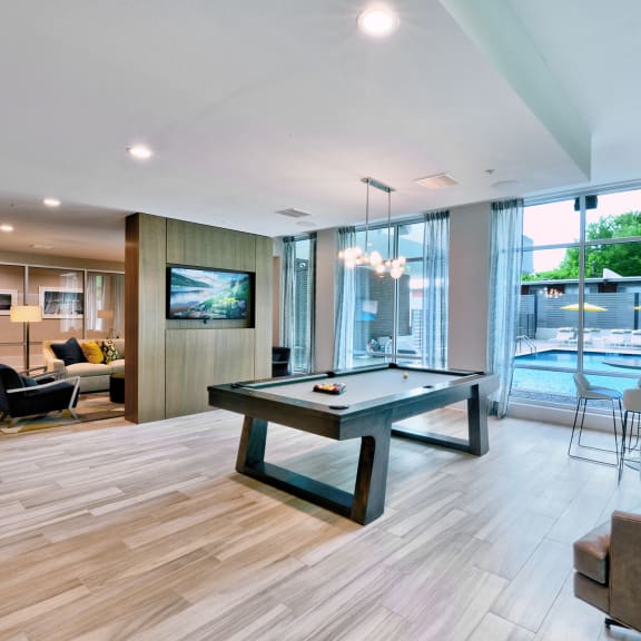 Memphis, TN Luxury Apartments For Rent - The Citizen - Clubhouse Lounge With Wifi, Billards, TV, Plenty Of Seating Areas, View Of The Pool, And A Table