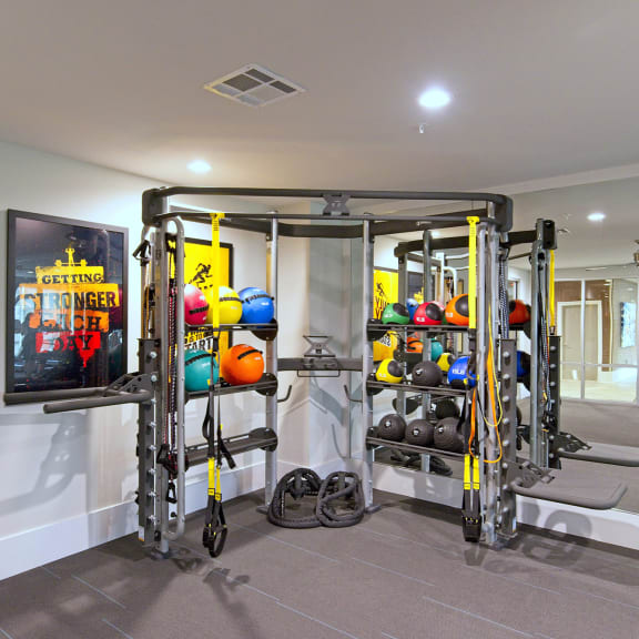 a fitness room with weights and a tv on the wall