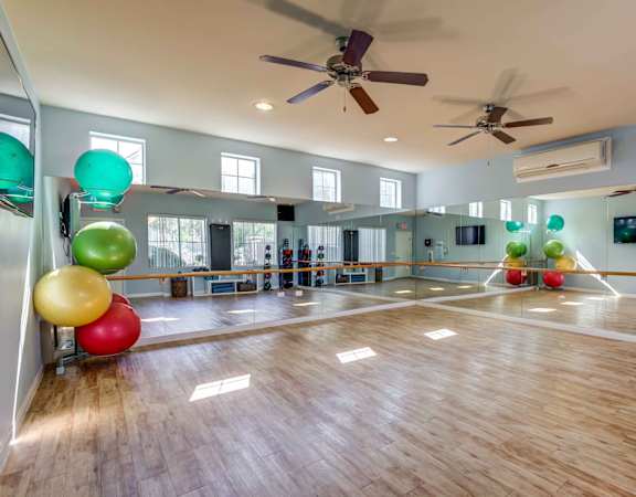A room with wooden floors and a ceiling fan.