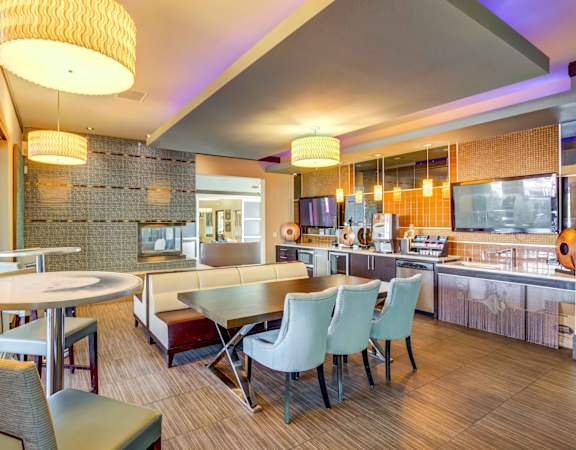 A modern kitchen and dining area with a wooden floor and a mix of white and dark furniture.