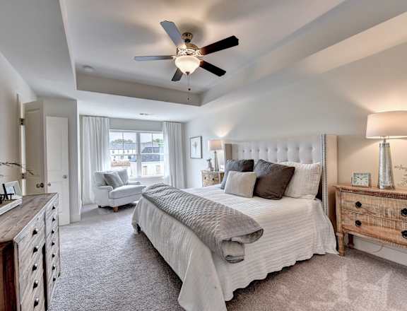 a bedroom with a large bed and a ceiling fan