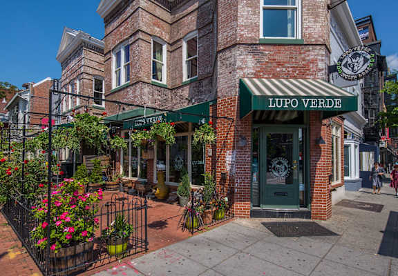 A brick building with a green awning that says "LUPO VERDE".