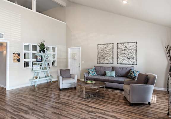 A living room with a grey couch, a white chair, and a coffee table.