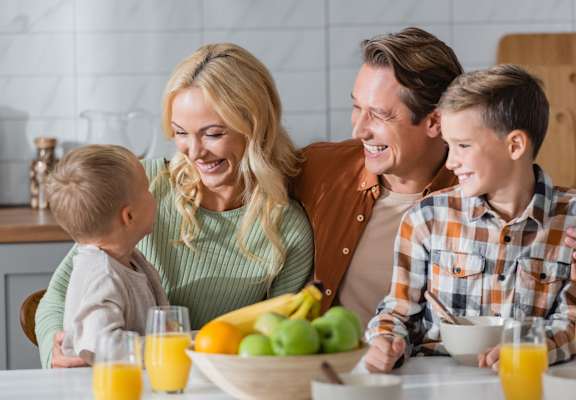 a family of four eating breakfast together