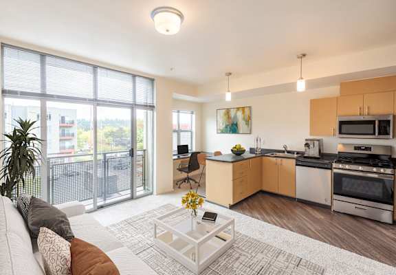 a living room with a couch and a coffee table and a kitchen with a sink