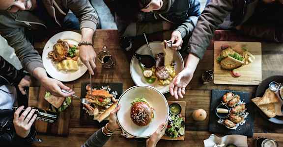 people sitting around a table eating food