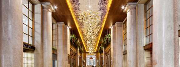 A long hallway with a carpeted floor and columns on either side.