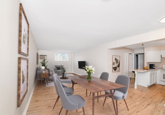A dining room with a wooden table and grey chairs. at The Alpine Apartments, Kettering, Ohio