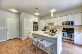 Kitchen with Bar Seating, Hardwood Inspired Floor and Ceiling Lights
