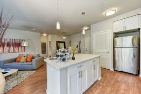 Kitchen with Refrigerator, Hardwood Inspired Floor, and Gray Sofa