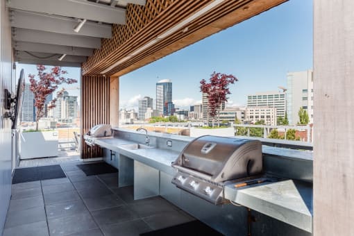 an outdoor kitchen with a grill and a view of the city