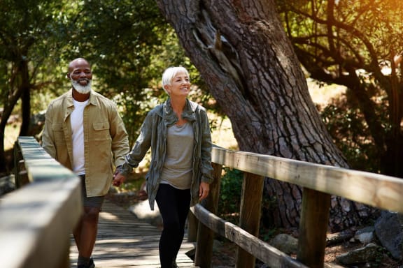 a man and a woman walking down a wooden bridgeat Mariposa at Elk Drive, Texas