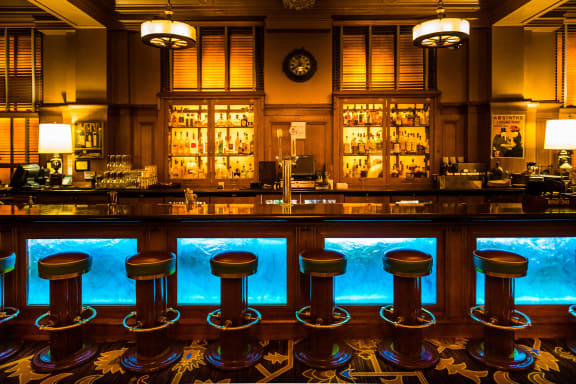 a bar with stools in front of a window with a view of the ocean