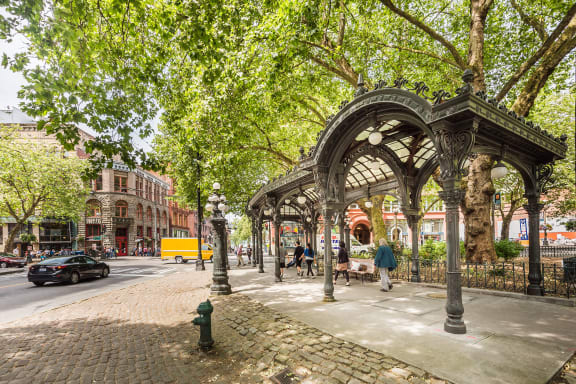 a city street with people walking and cars driving on the road