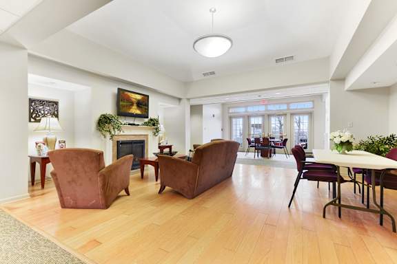 A living room with a fireplace and a dining table   at Summit Wood Apartments, Watertown, 13601