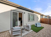 Thumbnail 4 of 5 - A small house with a patio and a small garden.