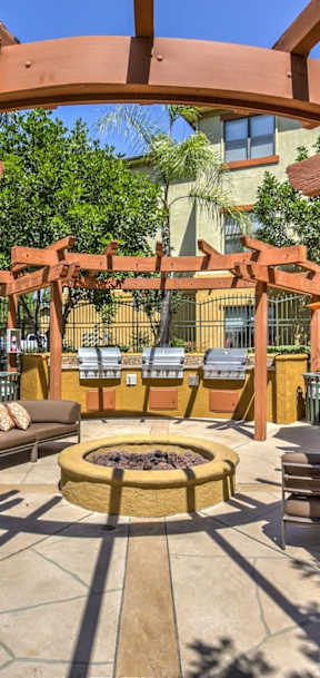 A patio with a fire pit and seating area.