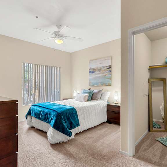 A bedroom with a bed, nightstand, and a wooden headboard.