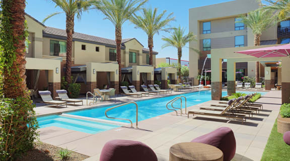 A pool surrounded by palm trees and lounge chairs at Audere Apartments, Phoenix, 85016