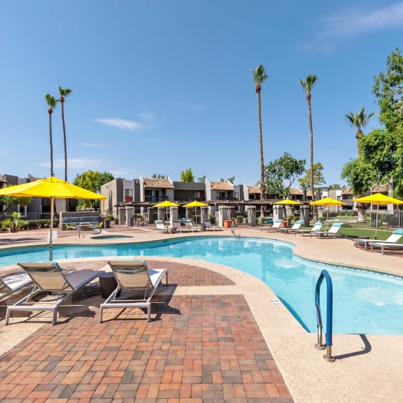 our apartments have a resort style pool with chairs and umbrellas