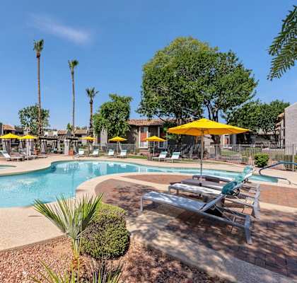 a swimming pool with chairs and umbrellas