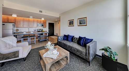 a living room with a couch and a coffee table and a kitchen at Parkhaus Apartments, Lincoln, NE