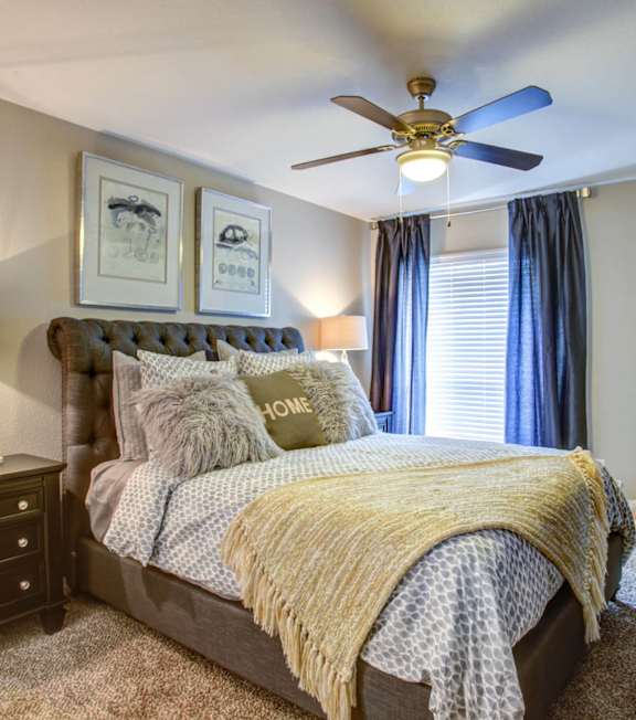 a bedroom with a bed and a ceiling fan