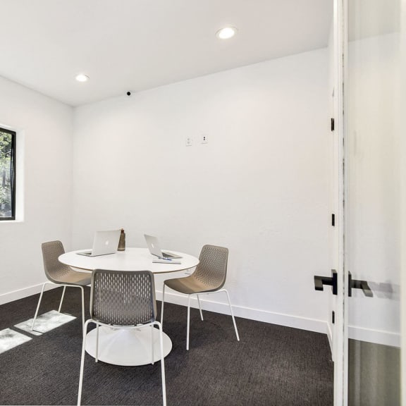 a small meeting room with a table and chairs