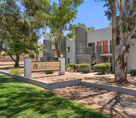 A modern building with a sign that reads "Acacia Hill" in front of it.
