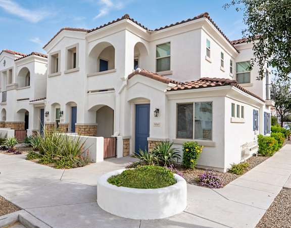 A row of houses with a white front yard and a small garden.